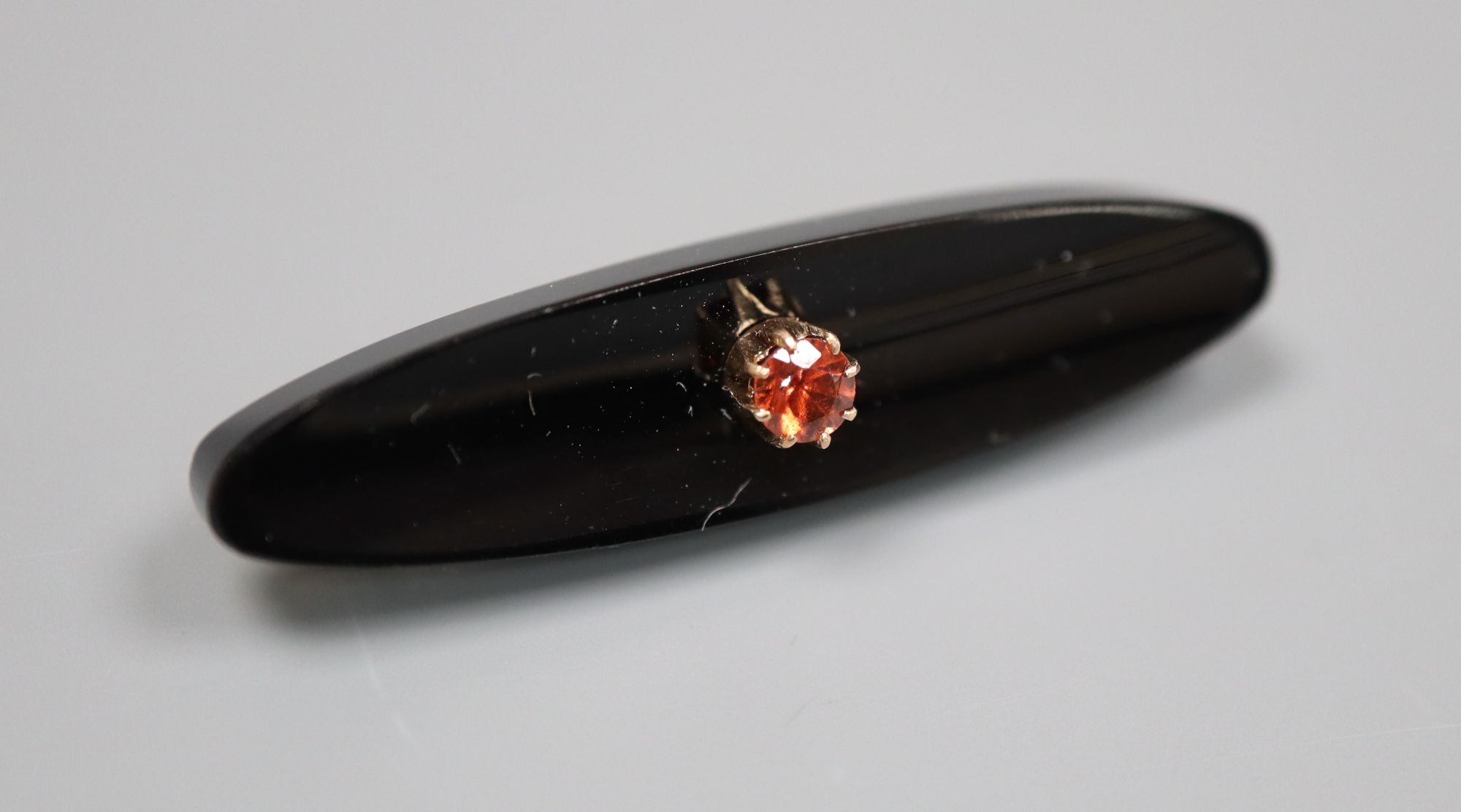 An early 20th century Russian 56 zolotnik yellow metal, black onyx and orange stone set ovoid brooch, 43mm, gross 7.3 grams.
